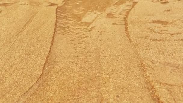 Corriente de agua de flujo rápido en lecho de arena fina llevando arena a lo largo, creando diferentes patrones. Macro
. - Metraje, vídeo