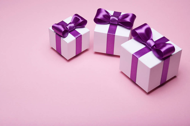 Geschenke mit Satinschleifen auf rosa Hintergrund - Foto, Bild