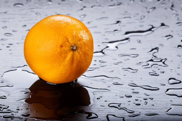 Orange a stříkající vody černém pozadí - Fotografie, Obrázek