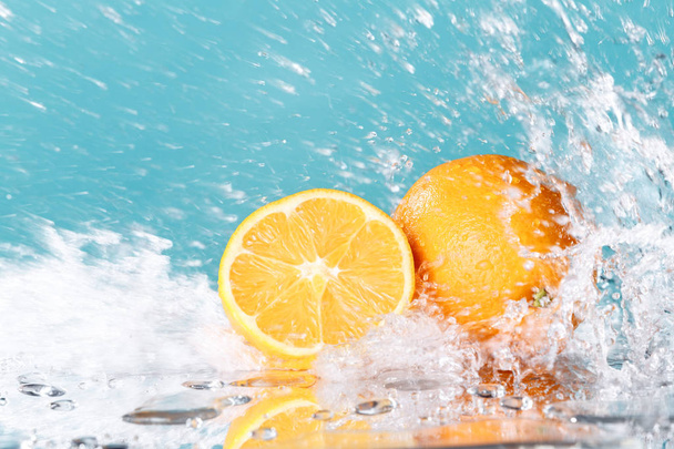 fris oranje met water splash op groene achtergrond - Foto, afbeelding