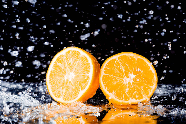 naranja fresca con salpicaduras de agua sobre fondo negro
 - Foto, imagen