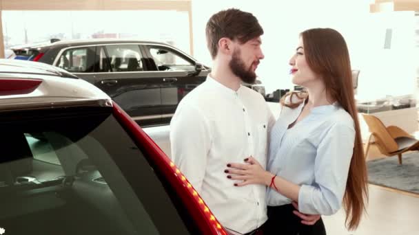 Para ogarnia sobą w pobliżu samochód na dealerskiej - Materiał filmowy, wideo