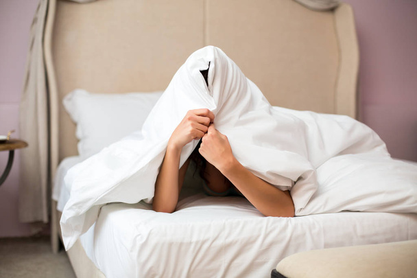 Woman hiding under a blanket. - Φωτογραφία, εικόνα