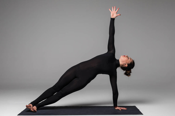 Belle femme yoga pratique des poses de yoga sur fond gris
. - Photo, image