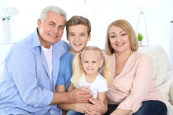 Cute children with grandparents sitting on sofa in living room - Photo, Image