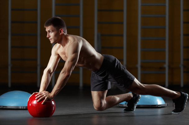 Man pushing on hands from floor medicine ball. - Photo, image