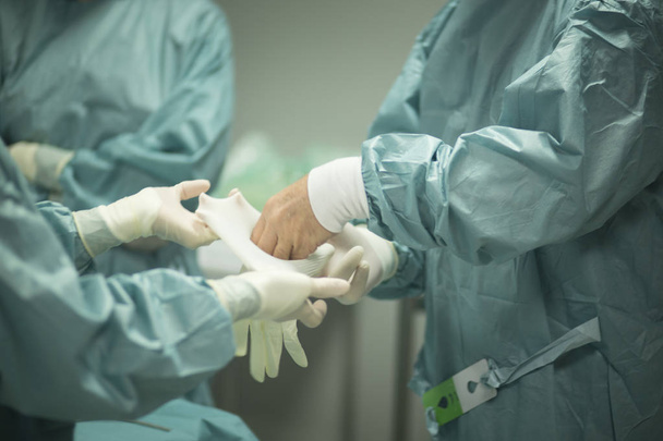 Chirurg si nasazuje rukavice - Fotografie, Obrázek