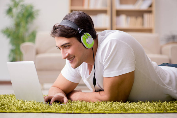 Fiatal ember hallgatta a zenét, a laptop - Fotó, kép
