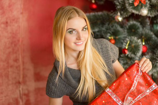 smiling woman in sweater with gift boxes - Foto, Imagen