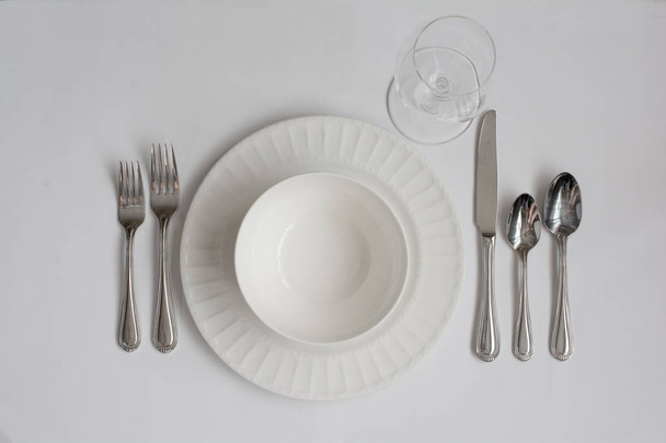 Muodollinen illallinen paikka asettaminen astiat valkoinen viini lasi
 - Valokuva, kuva