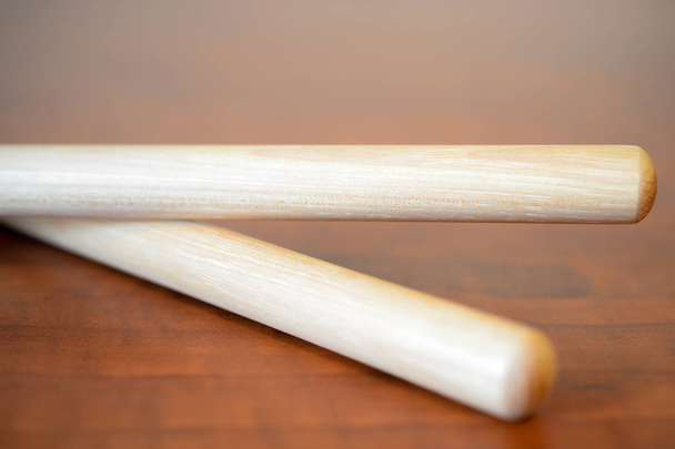 Пара барабанных палочек на искусственной деревянной поверхности
 - Фото, изображение