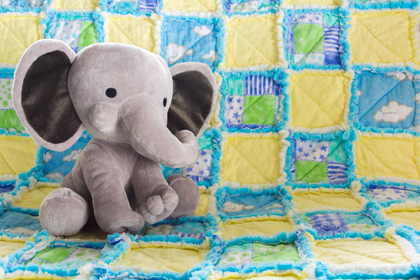 Cute Baby Elephant Stuffed Animal on a Colorful Quilt - Photo, Image