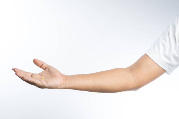 Χέρι με κίτρινο χάπι στην παλάμη - Φωτογραφία, εικόνα