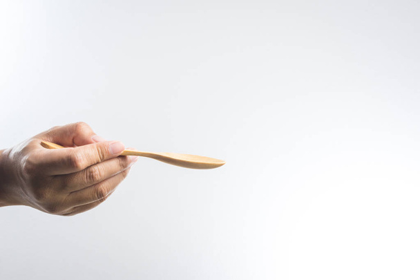 Man hand holding a wooden spoon - Foto, afbeelding