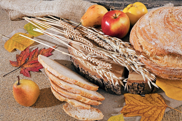 Dekoráció kenyérrel, gabonával és gyümölccsel vászonalapon - Fotó, kép
