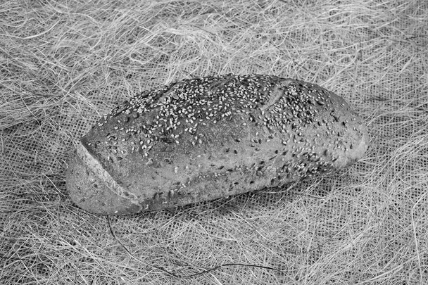 loaf of rye bread with seeds on linen cloth - 写真・画像