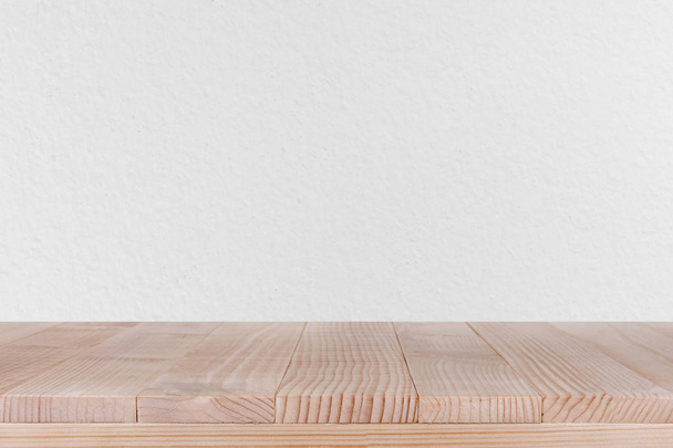 bruin houten tafelblad op witte betonnen muur achtergrond - kan worden gebruikt voor weergave van uw producten  - Foto, afbeelding