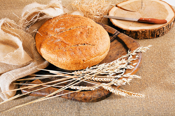 Decoration  with round integral bread on wooden board, note shallow depth of field - Photo, Image