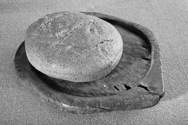 round integral bread on the wood board, note shallow depth of field - Photo, Image
