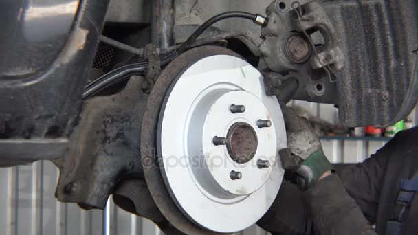 Mécanicien masculin renforcer nouveau disque de frein à la vieille voiture rouillée
. - Séquence, vidéo
