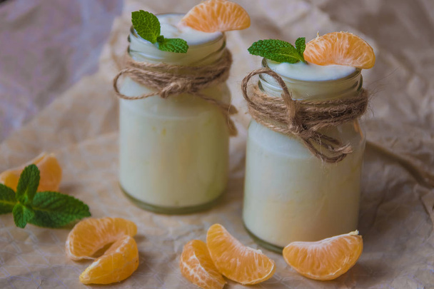 Organic yougurt with fresh tangerine and mint in glass jars  - Photo, Image