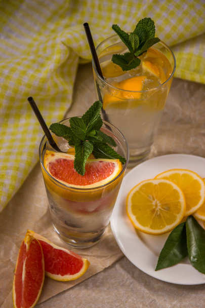 Two glass cups of water with red orange, lemon, mint and ice. Fr - Zdjęcie, obraz