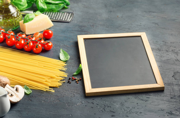 Leeg bord krijt met ingrediënten voor het koken van Italiaanse pasta - Foto, afbeelding