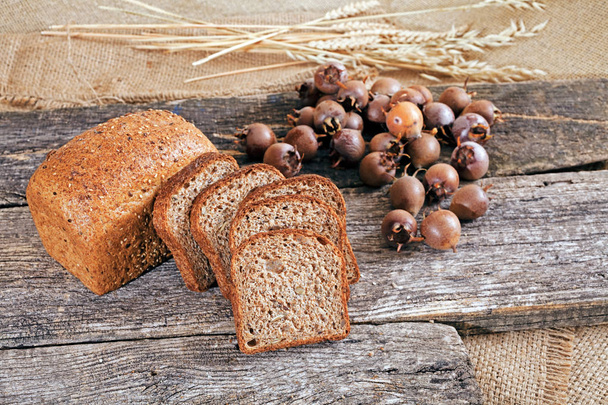 pain de seigle avec des graines sur une planche de bois avec un medlar autour
 - Photo, image