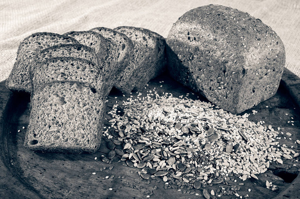 ψωμί σίκαλης με σπόρους σε ξύλινο πιάτο - Φωτογραφία, εικόνα