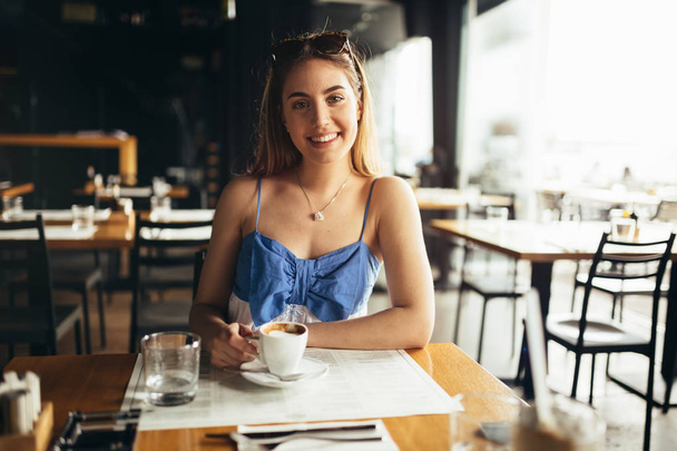 Woman drinking coffee in restaurant - Photo, image