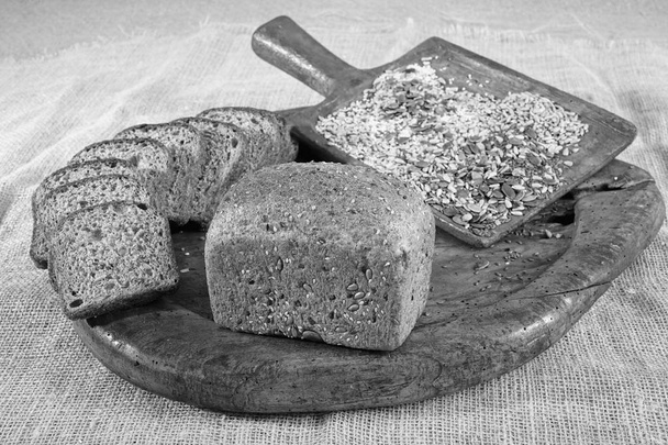 rye bread with seeds on a wooden plate - Photo, Image
