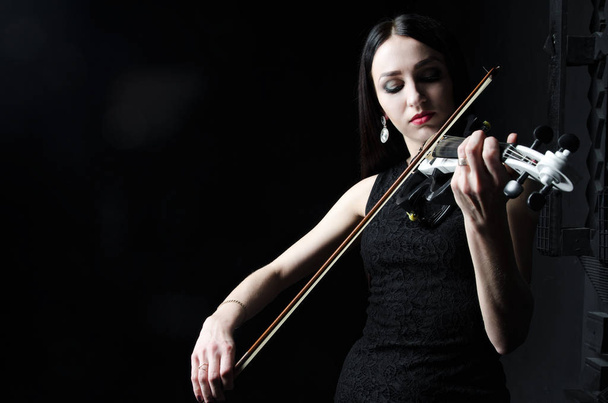 Beautiful woman playing the violin - Fotó, kép