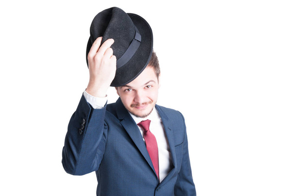 Młody człowiek ubrany garnitur zakładanie elegancki kapelusz  - Zdjęcie, obraz