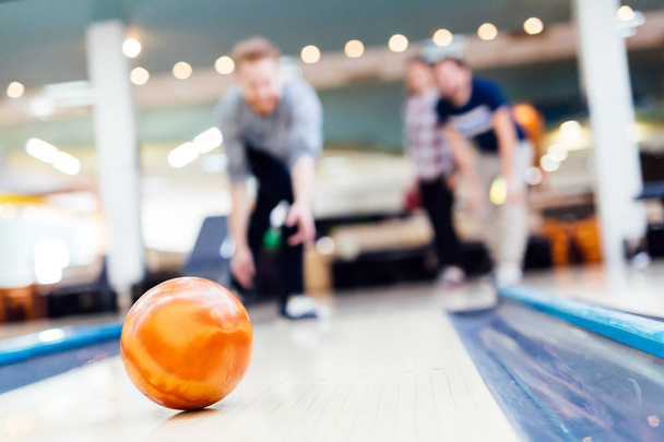 Friends enjoying bowling at club - 写真・画像