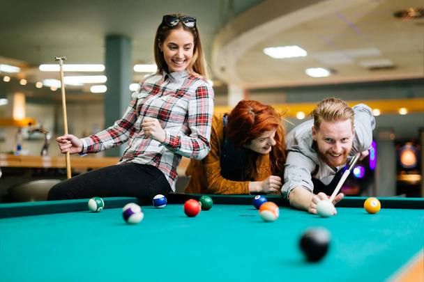 friends enjoying playing pool - Foto, Imagen