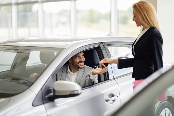 Salesperson selling cars at dealership - Photo, Image