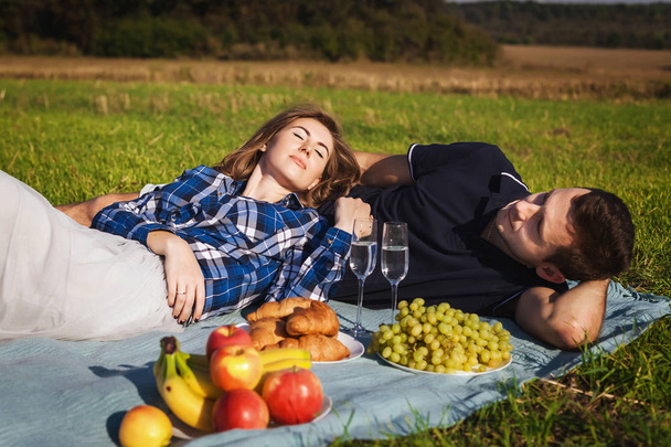 teenagers relaxing on a picnic. apples, grapes, croissants - Fotografie, Obrázek