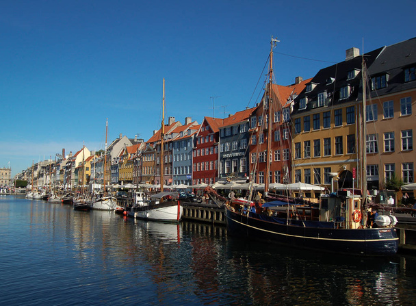 вид на будівлі Копенгагена на його річці на фоні блакитного неба
 - Фото, зображення