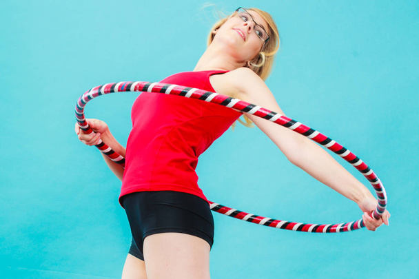 Fit woman with hula hoop doing exercise - 写真・画像
