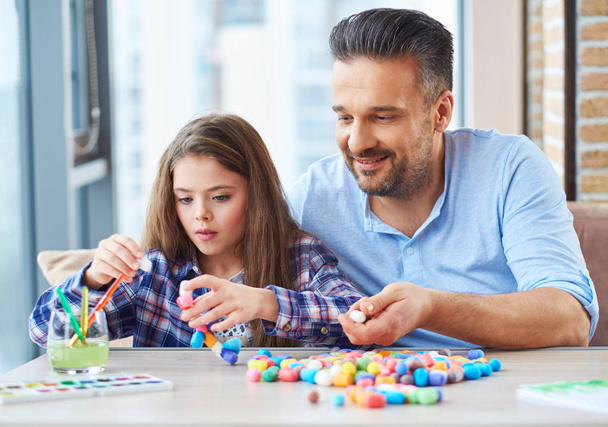 Beautiful little girl with her father playing with colored set for creativity - Φωτογραφία, εικόνα
