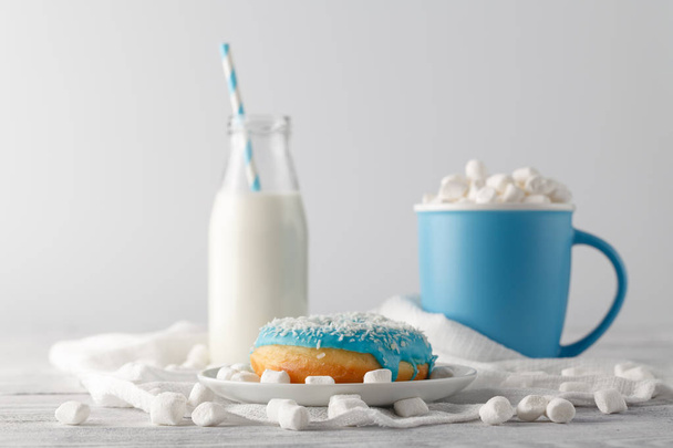 Mlue donut and cup o white table - Φωτογραφία, εικόνα