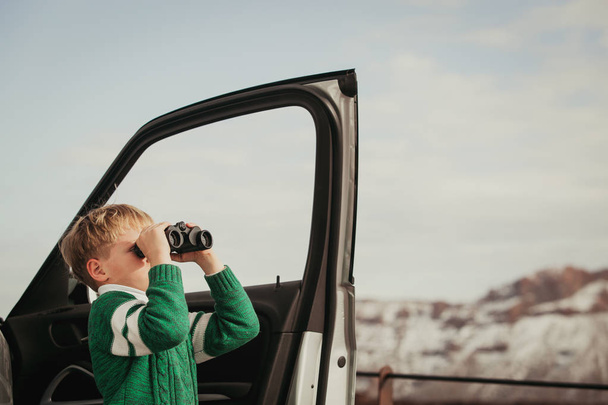 malý chlapec při pohledu přes dalekohled cestování autem v horách - Fotografie, Obrázek