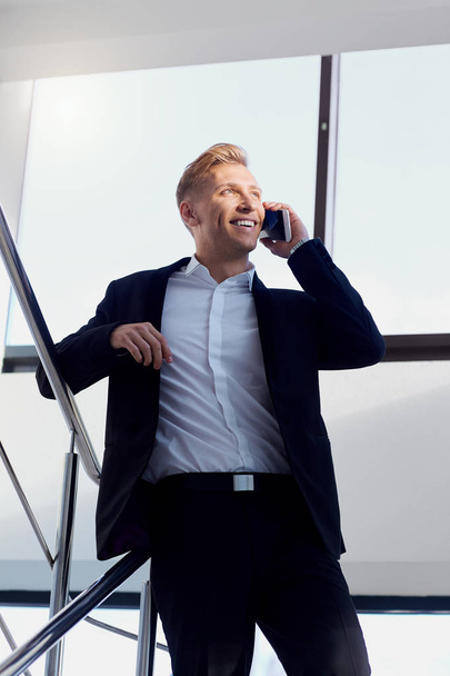 Businessman positive  blonde in a business suit talking on phone - Fotó, kép