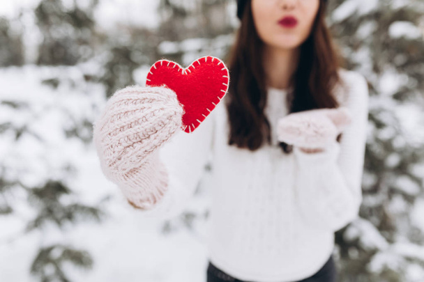 Girl holding heart in winter nature - Foto, afbeelding