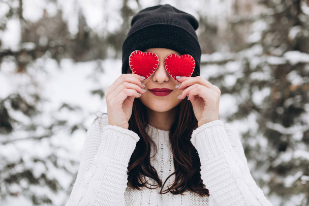 Chica sosteniendo corazones en la naturaleza de invierno
 - Foto, Imagen