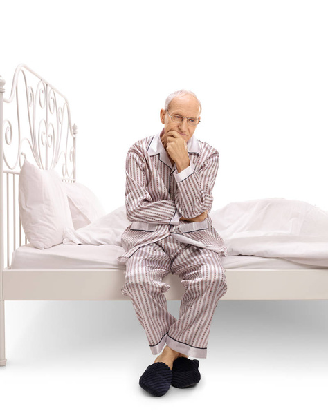 Pensive senior sitting on a bed - Photo, Image