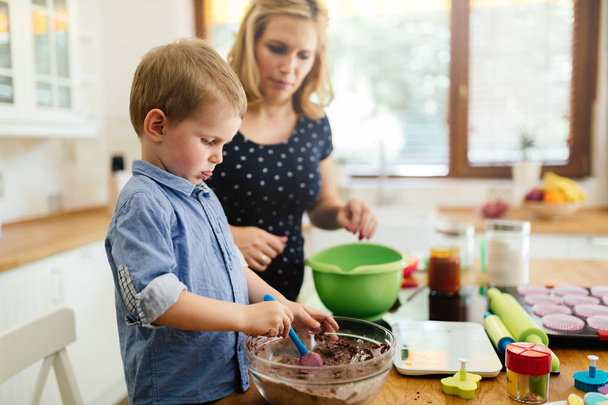 Smart cute child helping mother in kitchen - Foto, Imagem