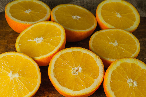 Frutas de naranjas y rebanada de naranja en mesa de madera y tela retro
 - Foto, imagen
