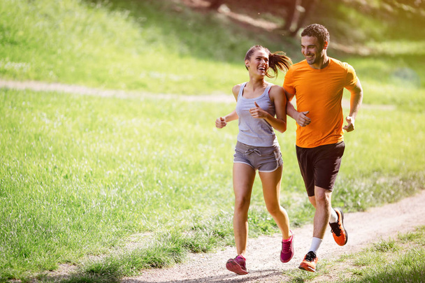 Couple jogging outdoors - Фото, изображение