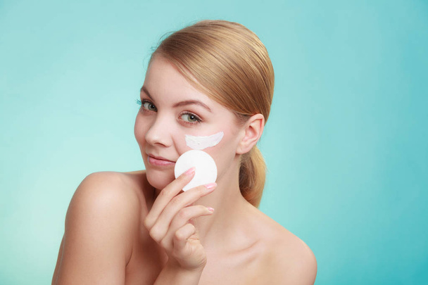 Woman removing makeup with cream and cotton pad - Φωτογραφία, εικόνα